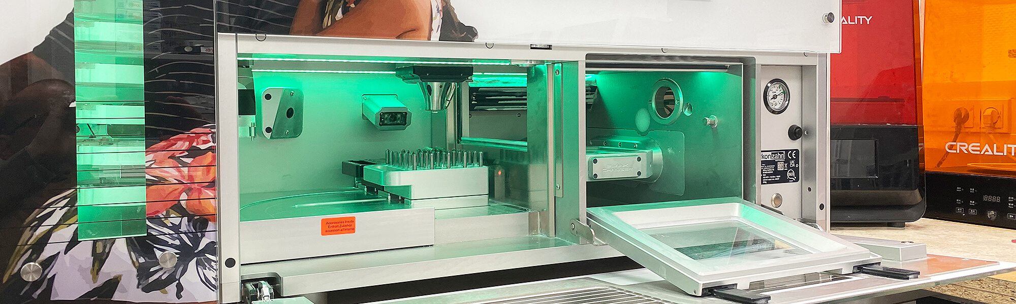 Geöffnete Fräsmaschine und 3D-Drucker im Dentallabor für die digitale Fertigung von Zahnersatz.