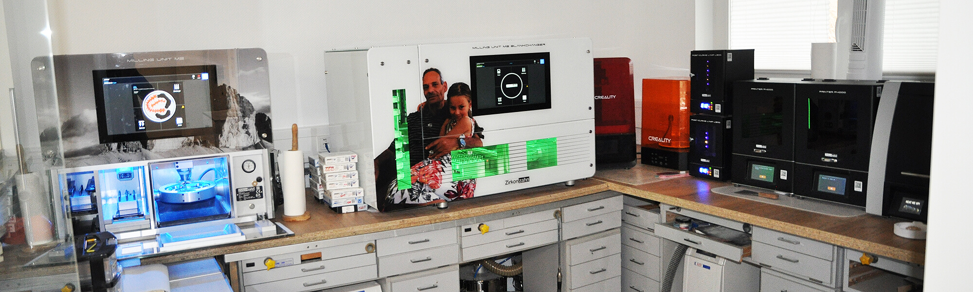 Digitaler Fertigungsbereich im Dentallabor mit CAD-CAM-Fräsmaschinen und 3D-Druckern.